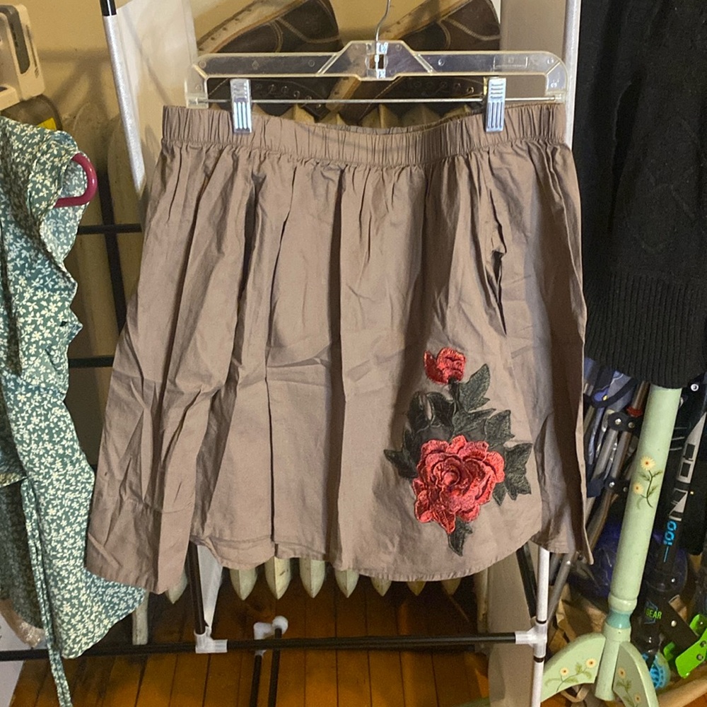 Off shoulder taupe top. Long sleeve and3D rose detailing at corner